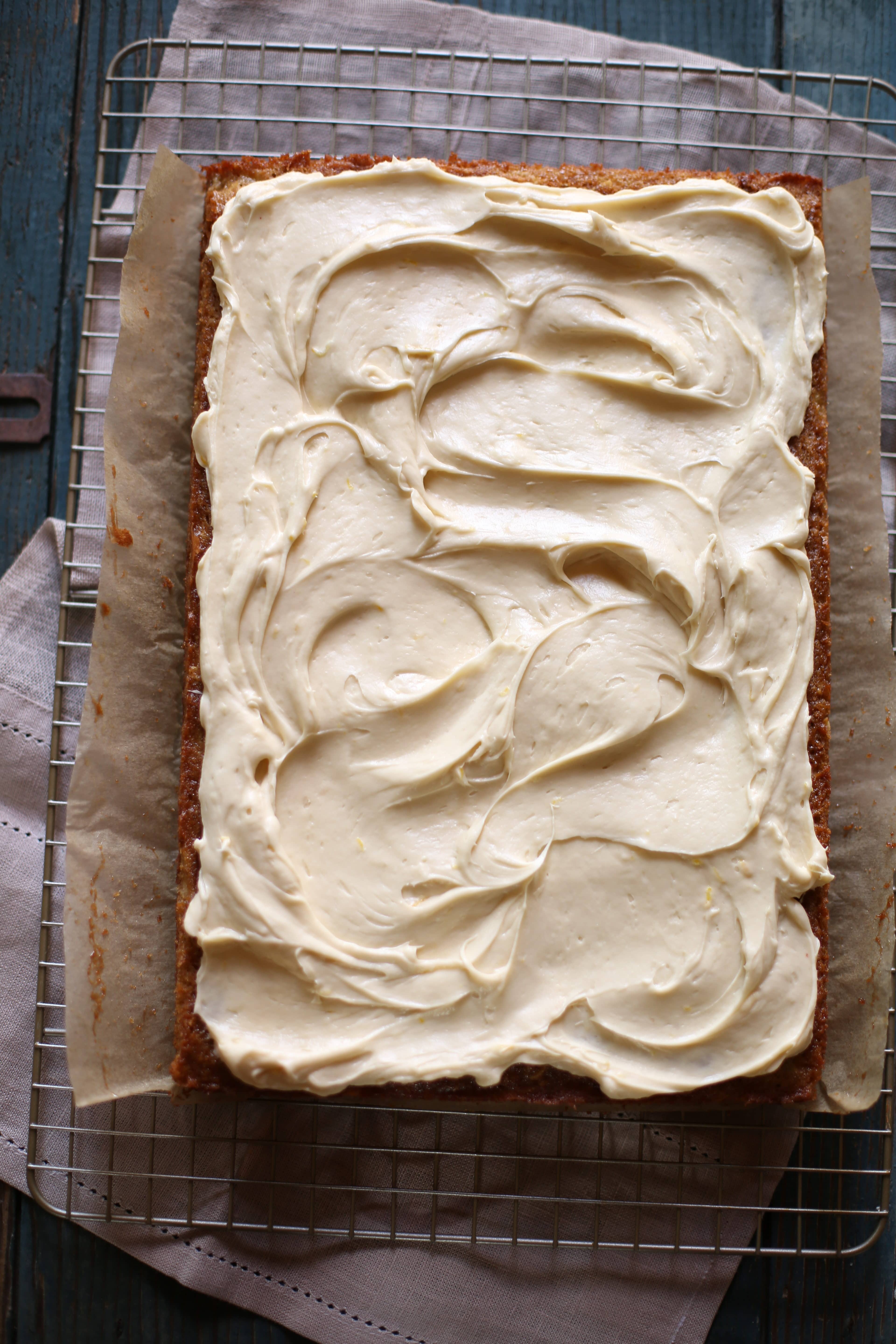 a frosted fresh banana cake on a rack