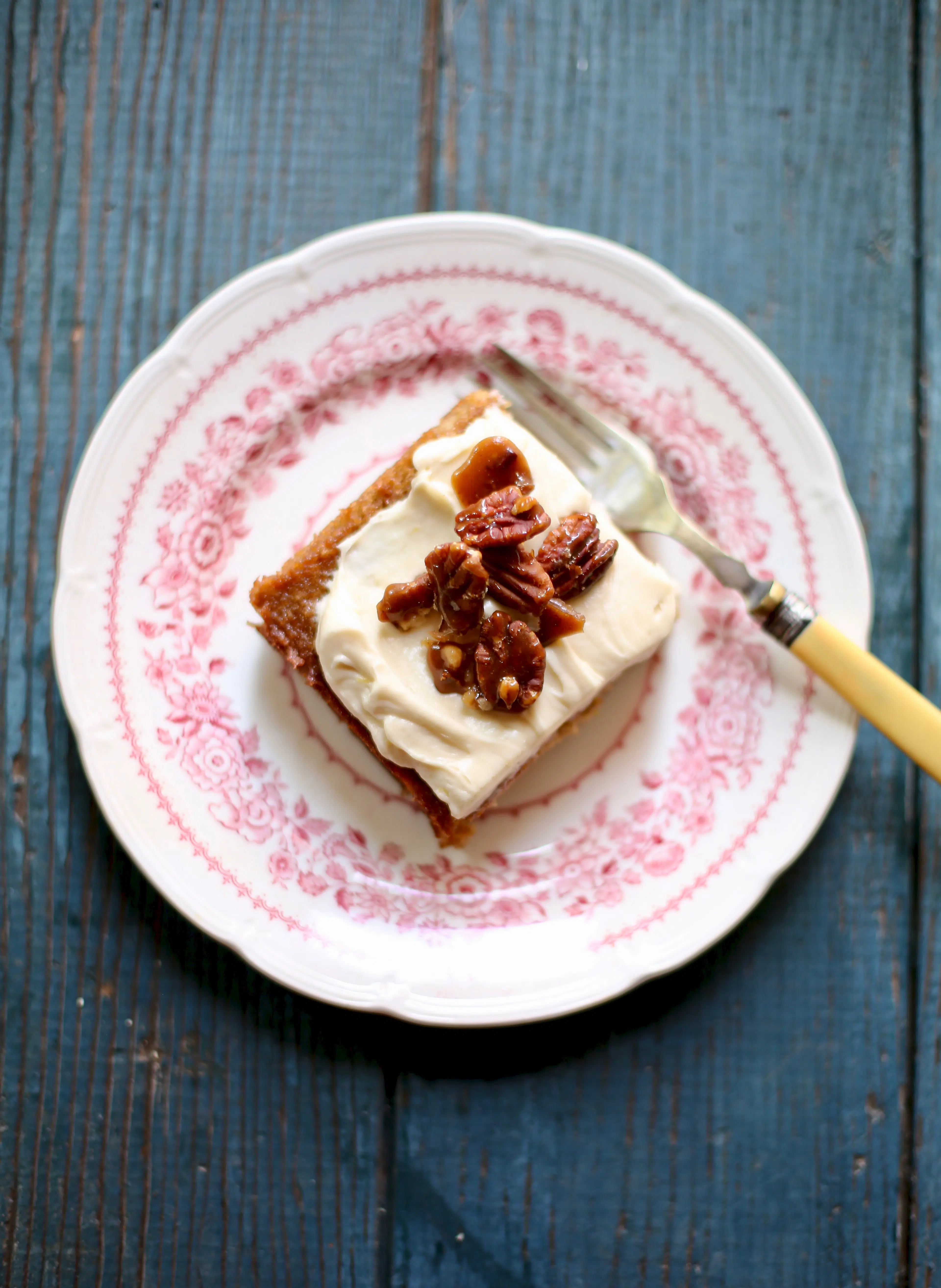 a piece of cake on a pink and white plate with a yellow fork