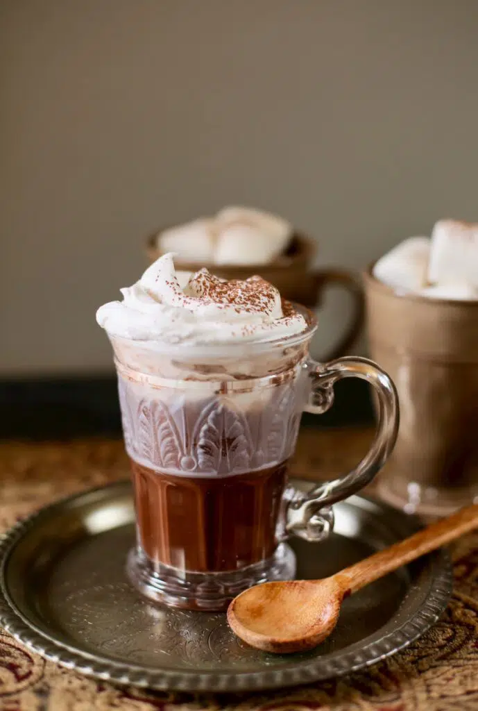 hot chocolate on a table with two other cups with marshmallows