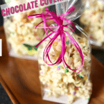 bag of cellophane wrapped popcorn with a pink ribbon. Text overlay says the recipe name.