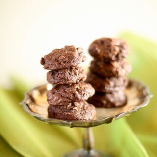 Chocolate cookies on a silver tray with green background