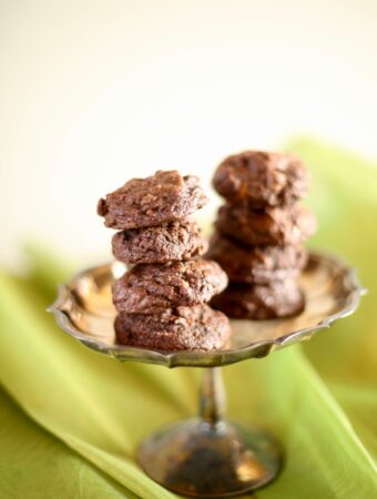 Chocolate cookies on a silver tray with green background
