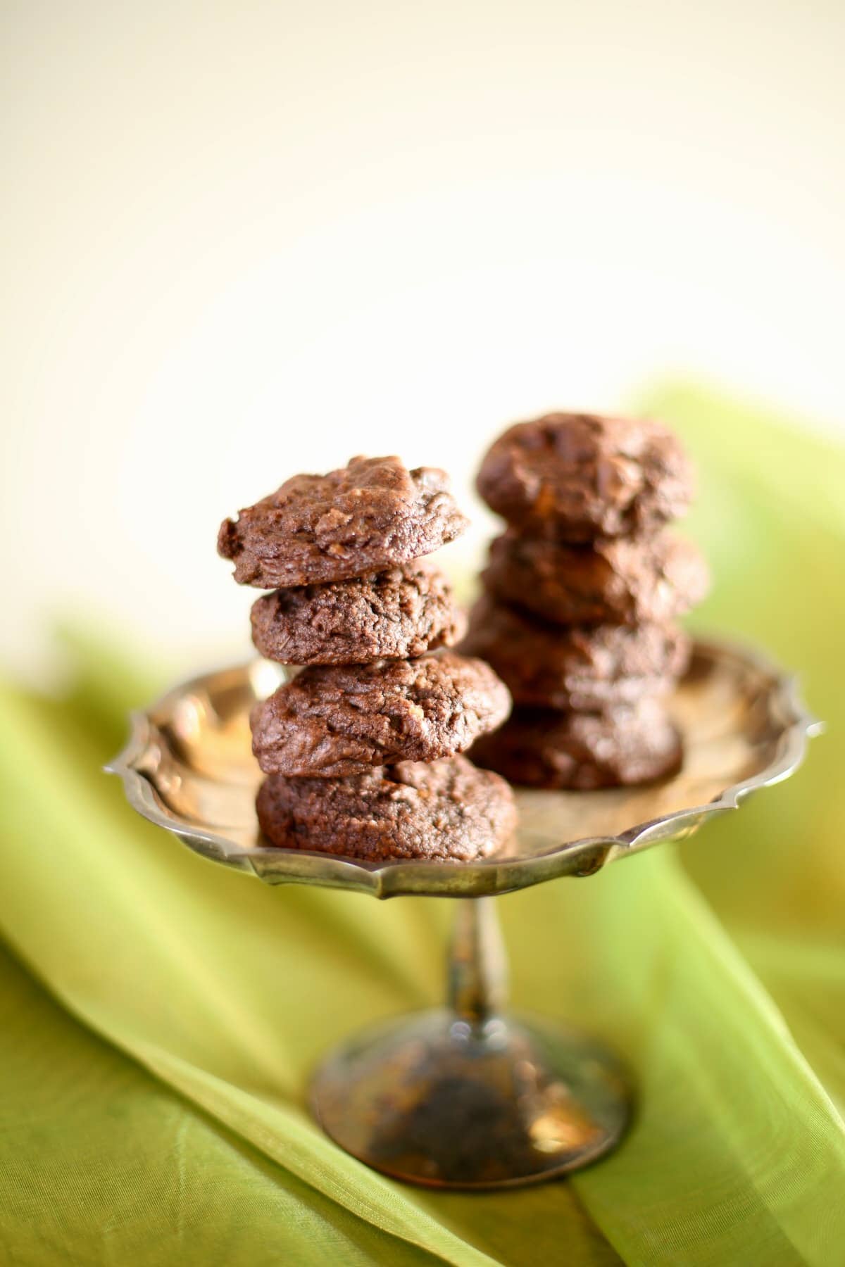 Chocolate cookies on a silver tray with green background