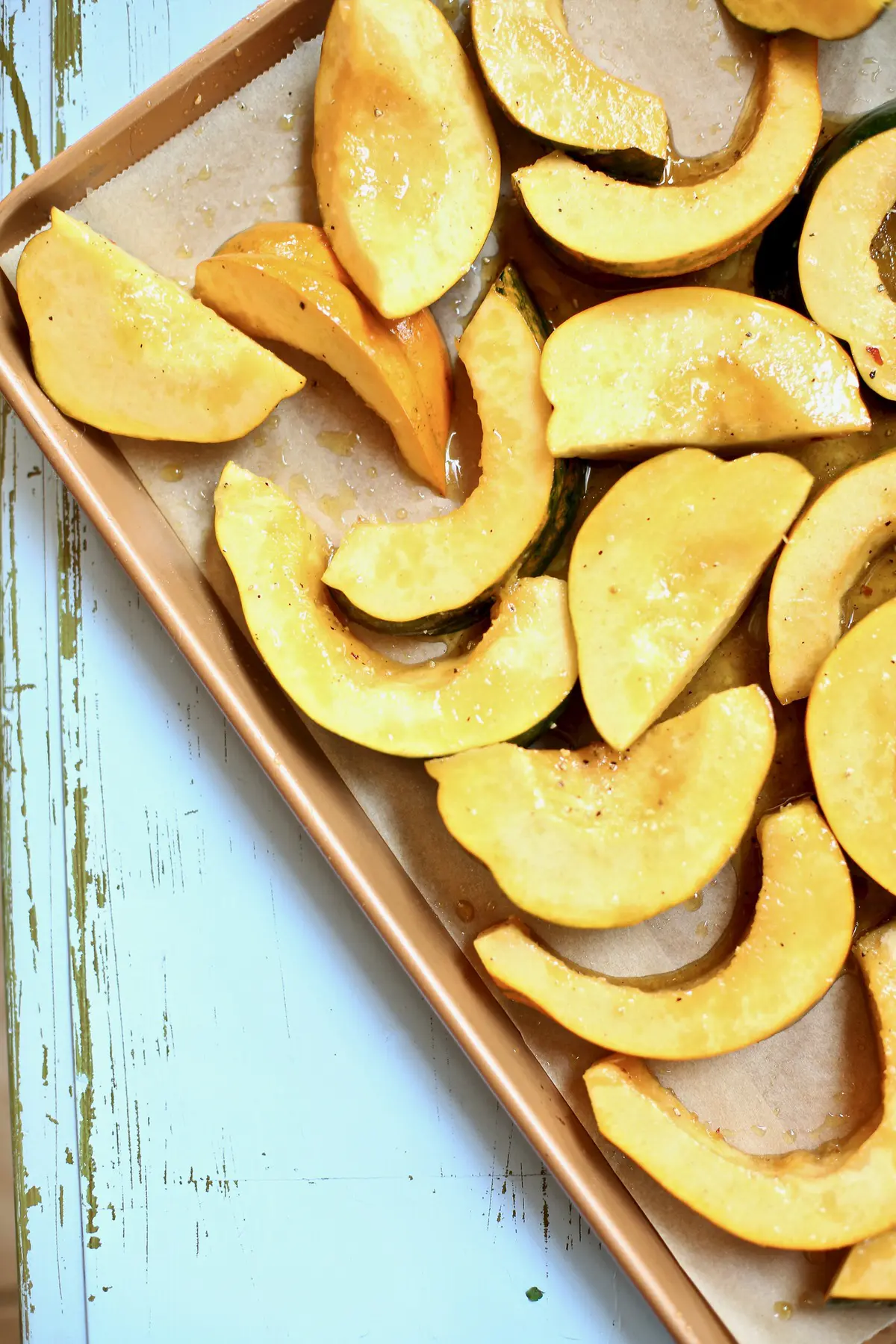 raw squash cut and on a baking sheet