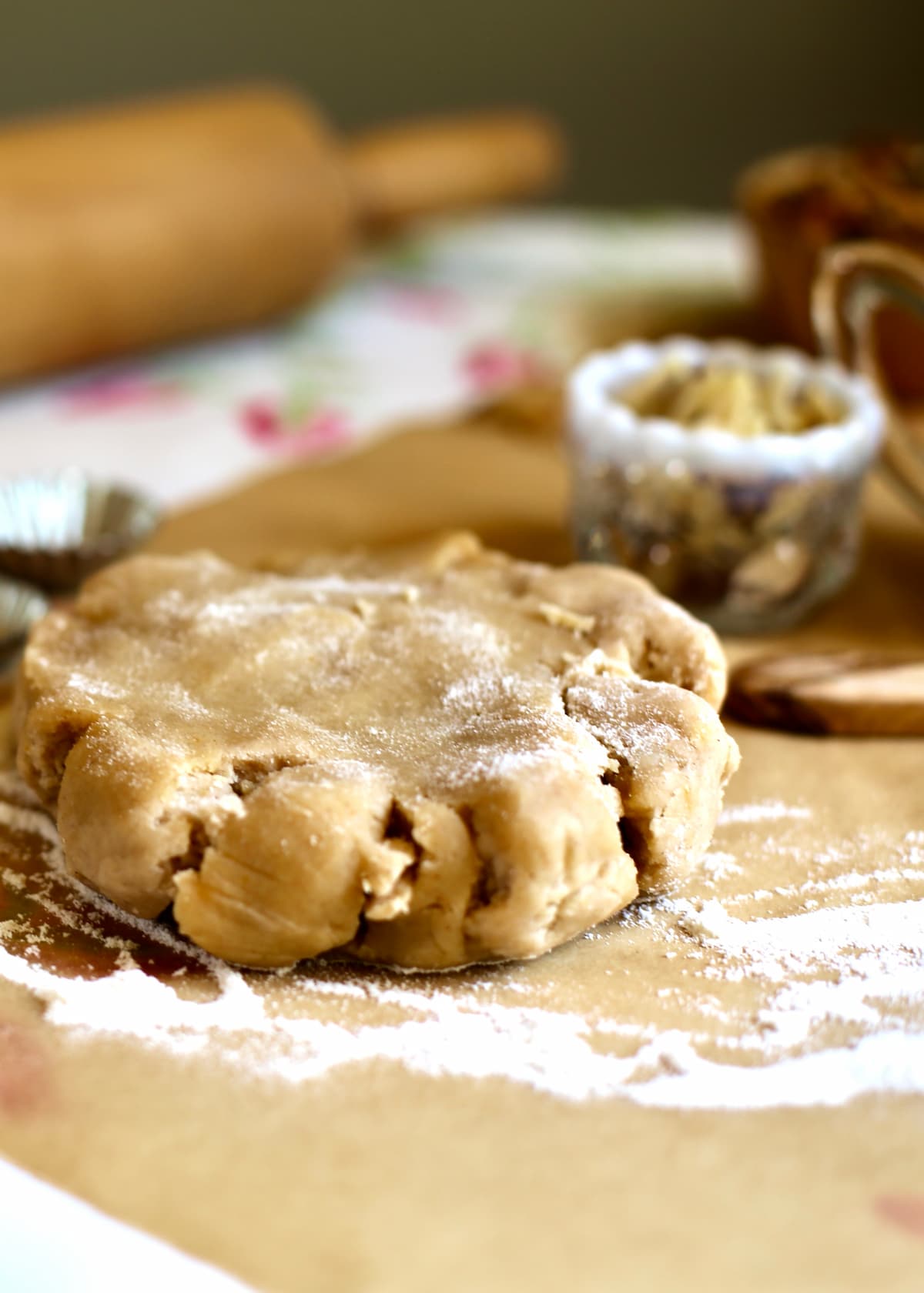 a disc of pie dough on a table with flour.
