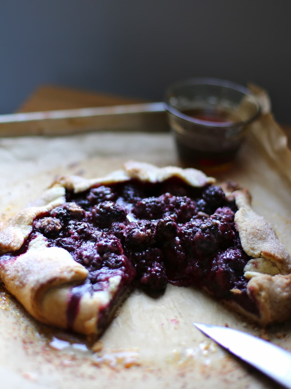 a berry galette with a piece out of the middle.