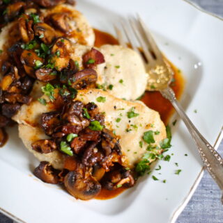 chicken on a white platter wih serving utinsil
