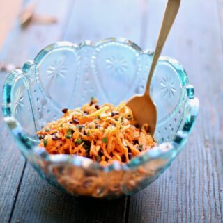 carrot salad in a blue bowl in a wood table