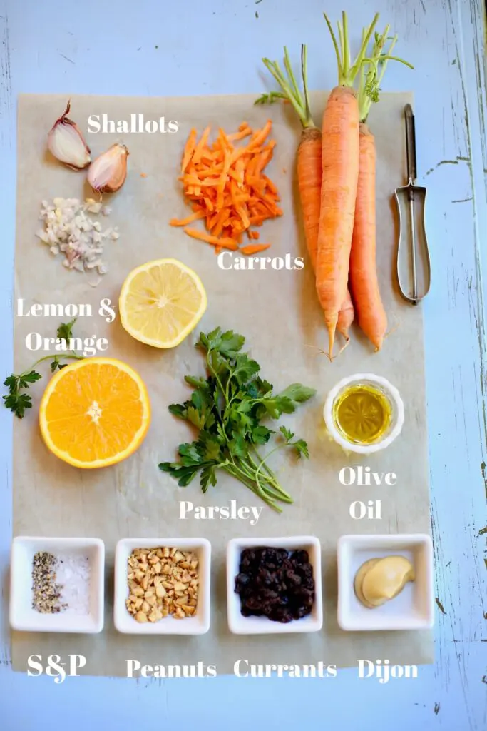 ingredients for carrot salad with text on a blue table