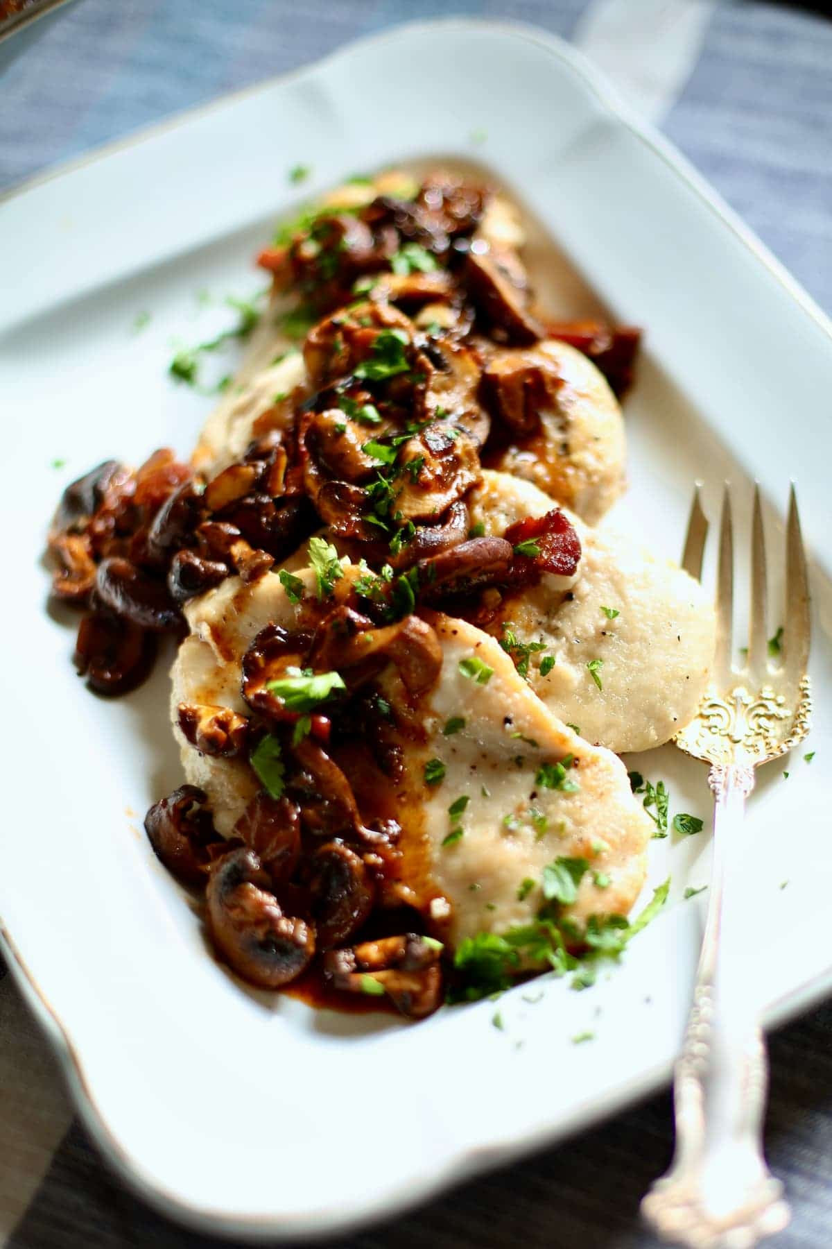 a seving tray with chicken marsala on it. 