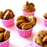 small cookies in pink cups on a table