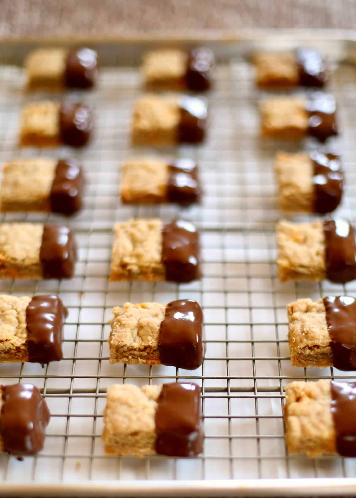a cooling rack of shortbread cookies dipped in chocolate.