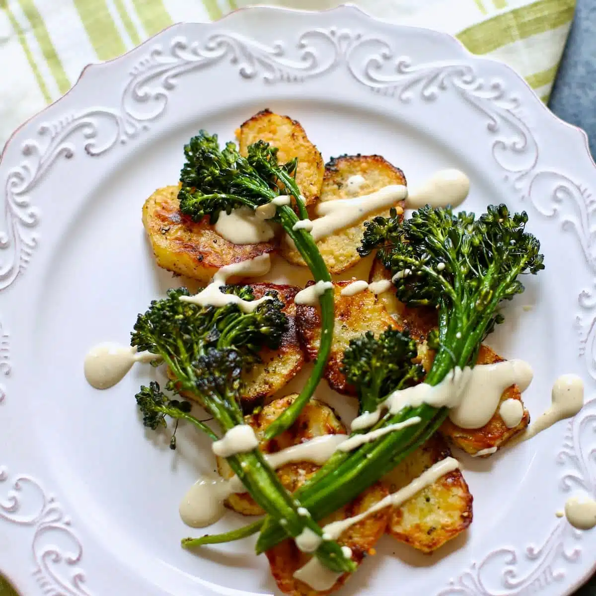 a square photo of broccolini and potatoes.