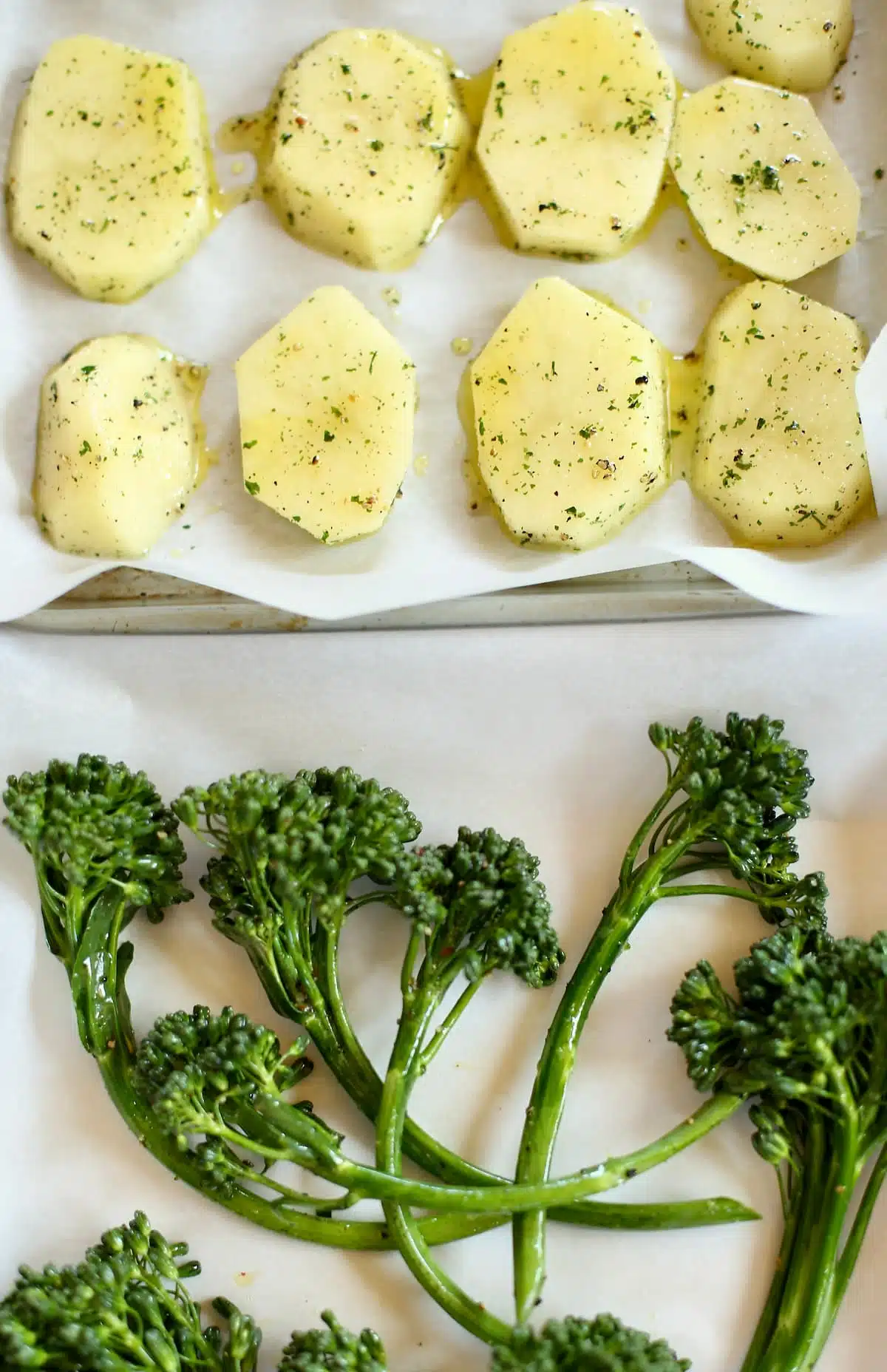 a baking sheet of potatoes and broccolini.