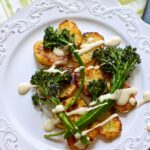potatoes on a white plate with broccolini on top and a text overlay for pinterest.