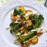 potatoes on a white plate with broccolini on top and a text overlay for pinterest.