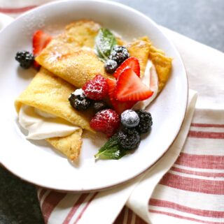 Crepes and berries on a white plate