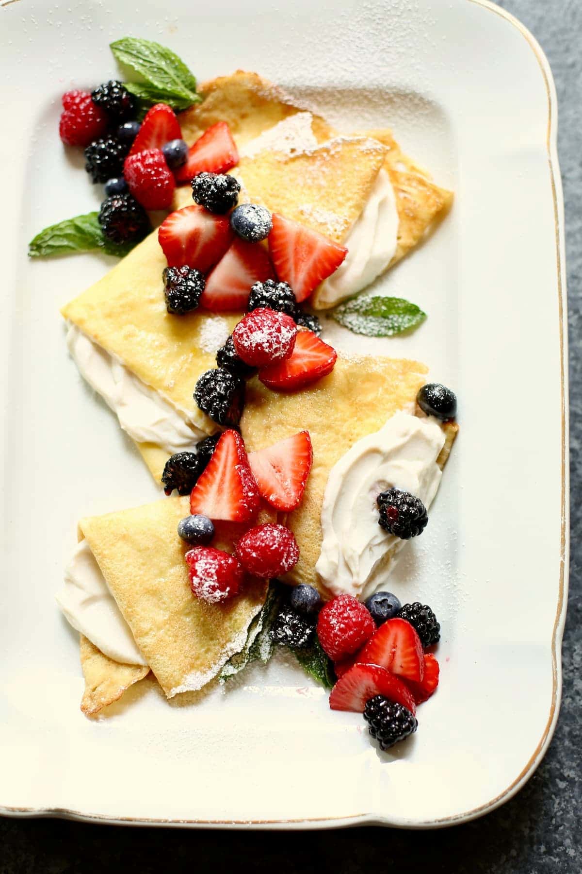 a large white platter with crepes on it.