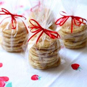 some gift wrapped cookies with red ribbon on a table.