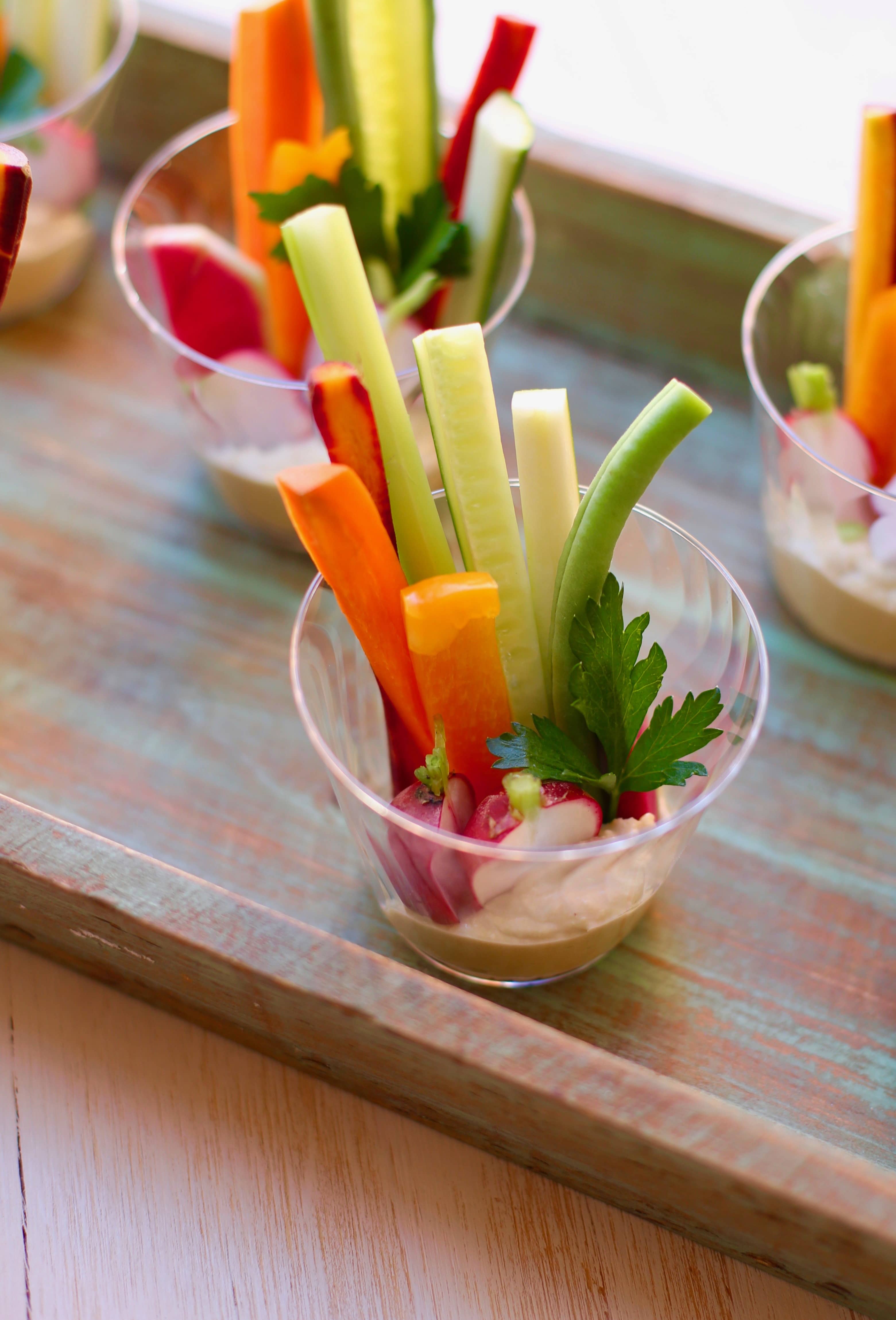 Veggie Cups with Hummus on a wooden tray 