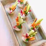 veggies in cups on a wooden board