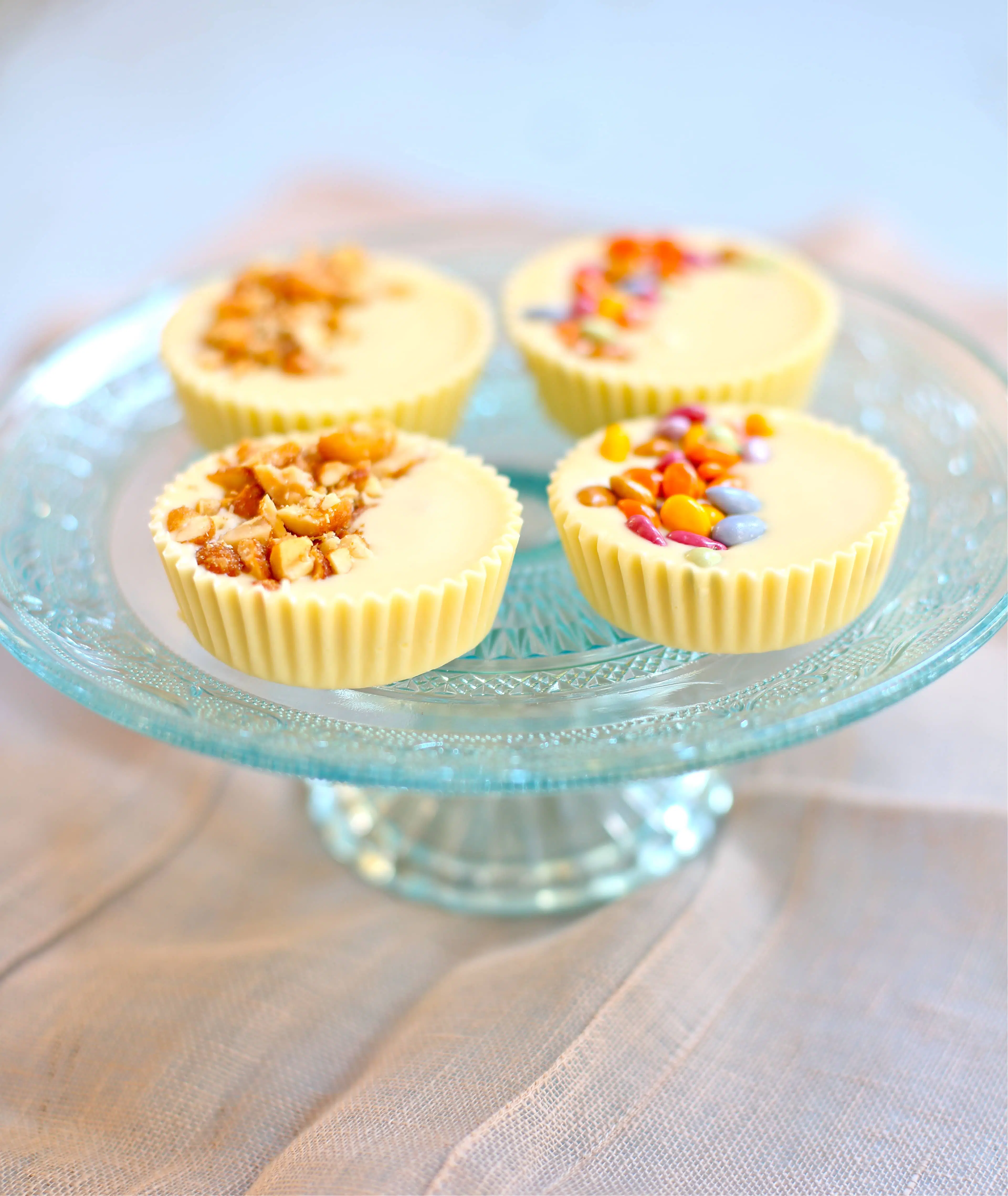 Four white chocolate peanut butter cups with candied topping and peanut topping