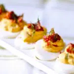 a tray of deviled eggs ona white dish