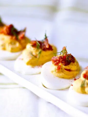 a picture of deviled eggs on a white serving tray.