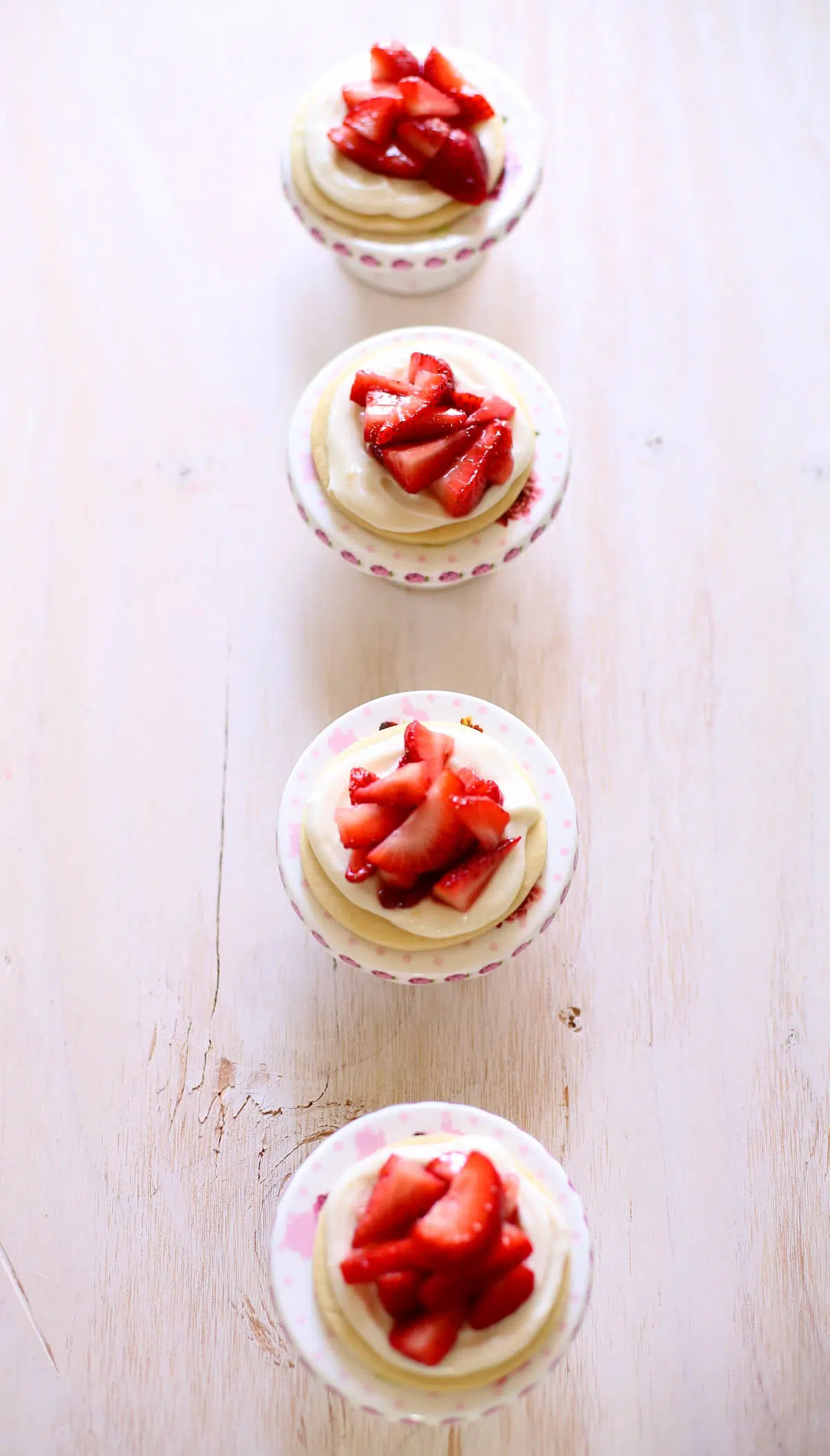 a row of cookies with strawberries on top.