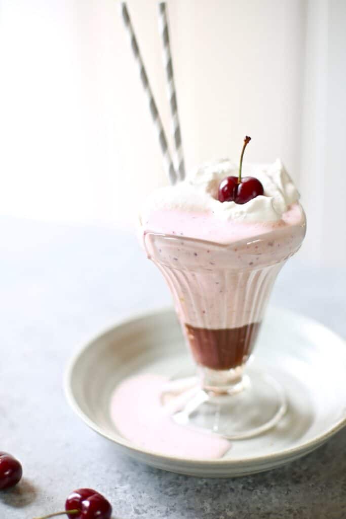 cherry milkshake on a gray plate and take with two gray straws