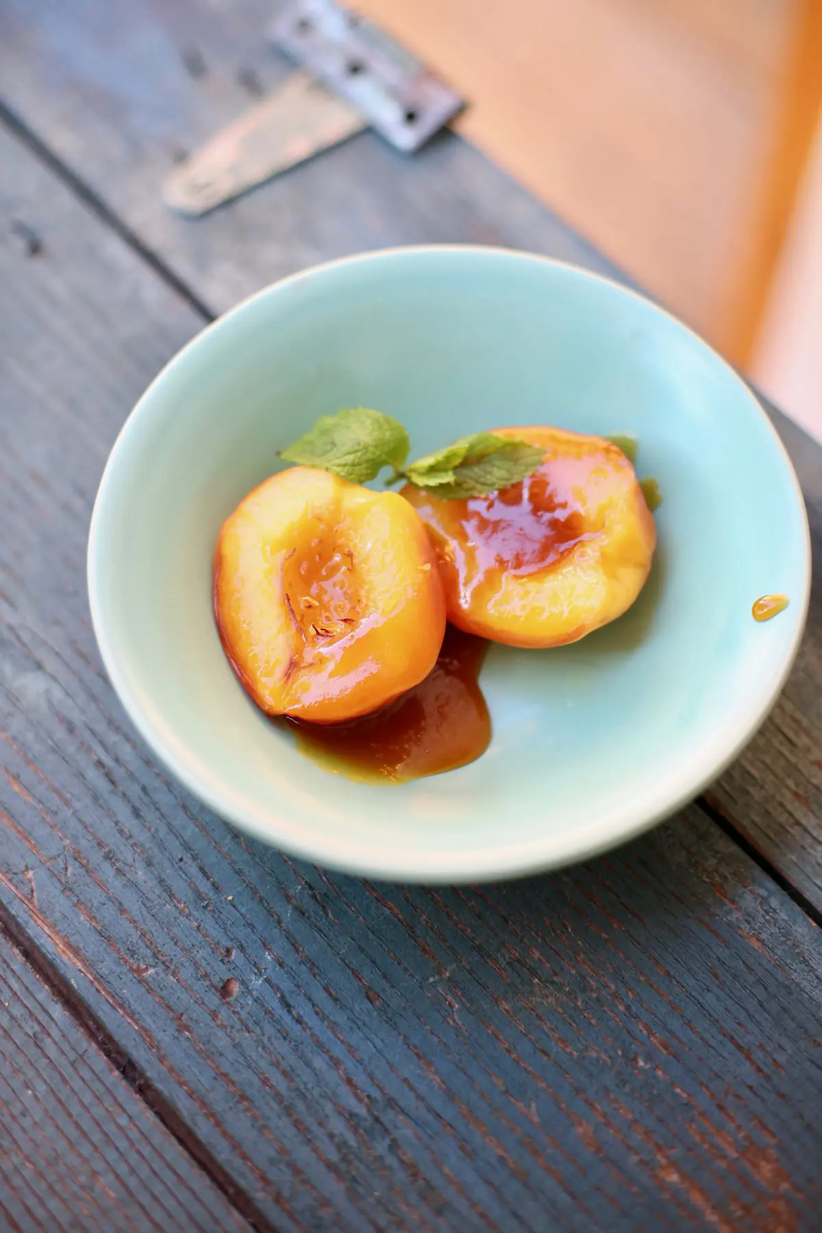Roasted nectarines in a blue bowl on a blue wooden table