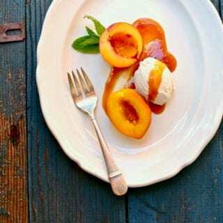 roasted nectarines on a white platter with a silver fork