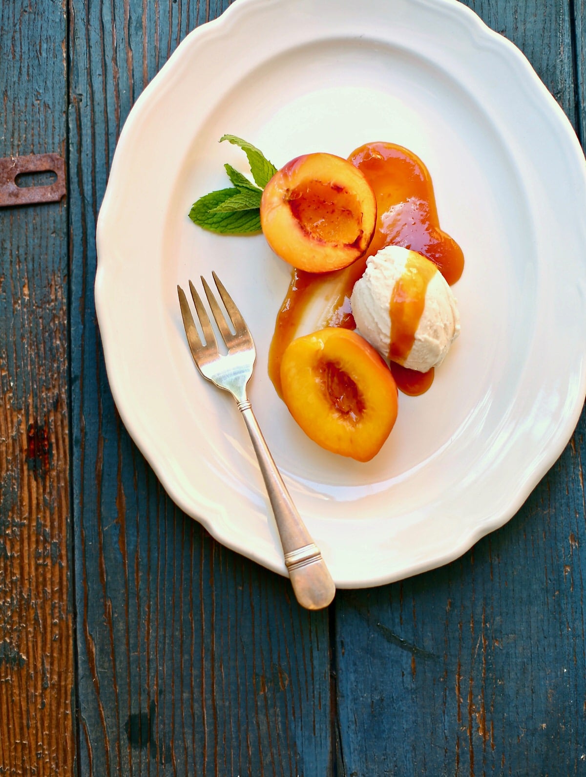 roasted nectarines on a white platter with a silver fork