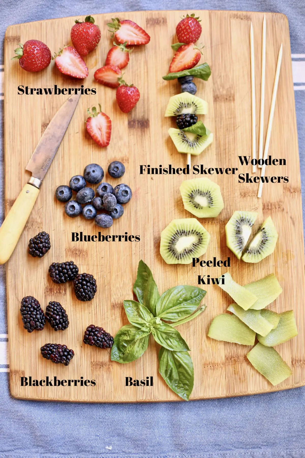 ingredients for a fruit kabob on a cutting board