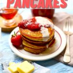 a table with a breakfast spread, pancakes, bacon, butter, strawberries, maple syrup and a fork, with text overlay saying the recipe name.