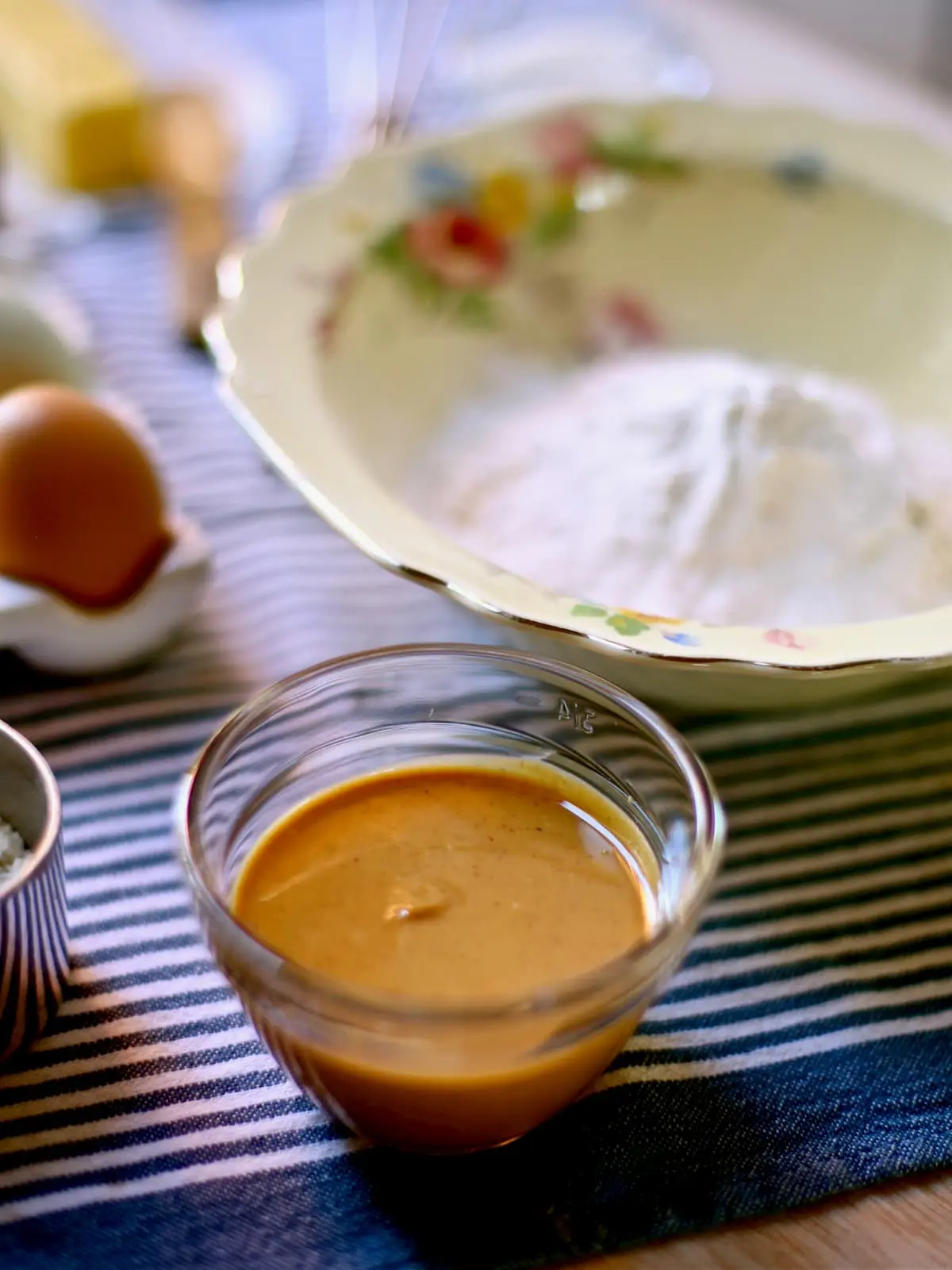 peanut butter and flour and eggs in containers on blue striped tablecloth