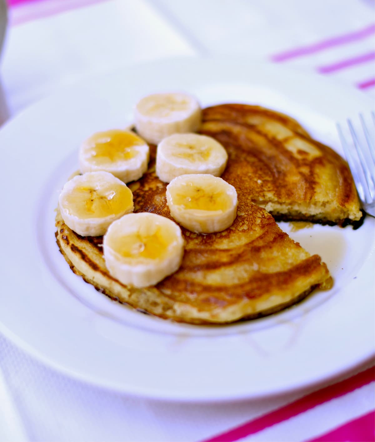 pancakes with bananas on a white plate 