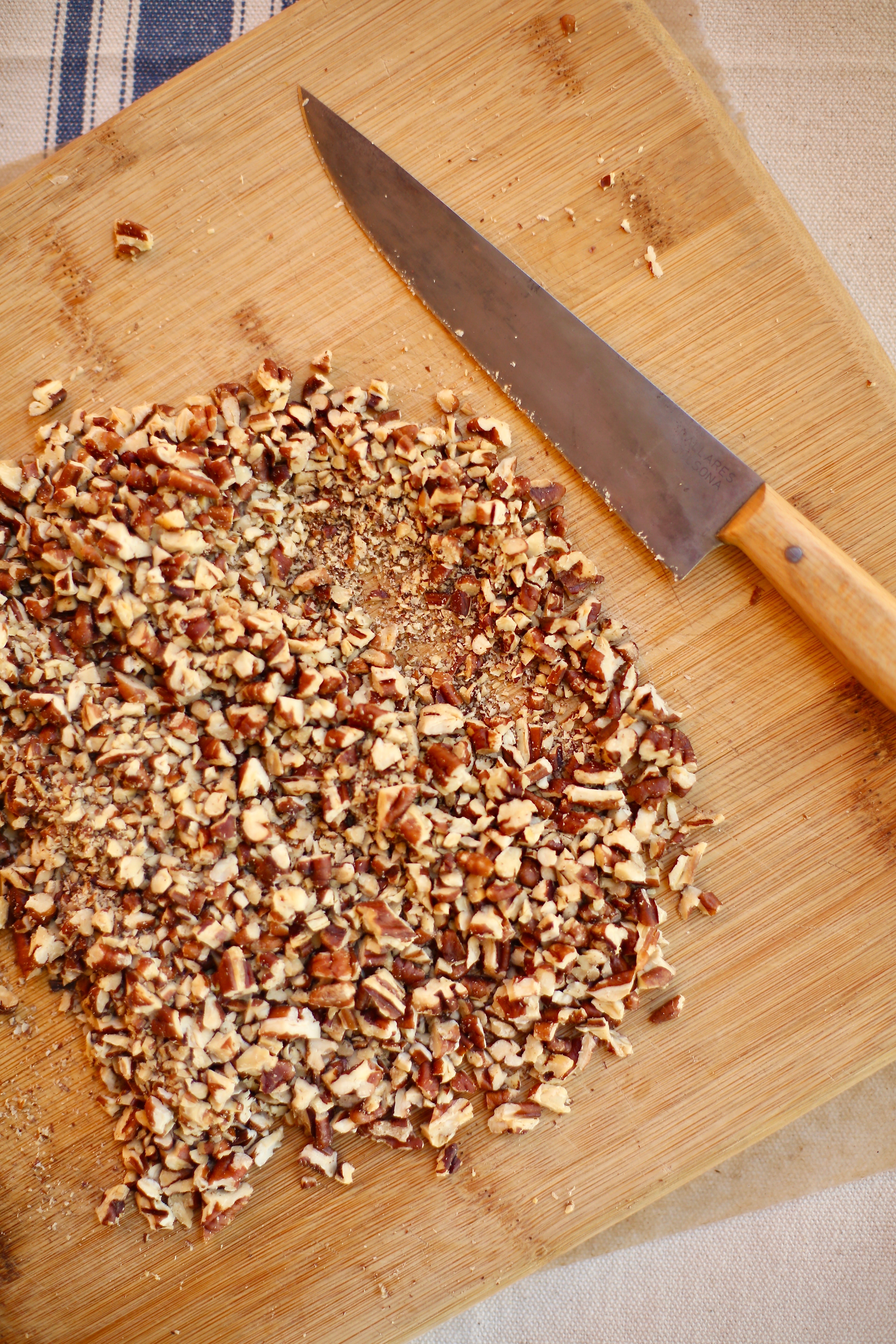Favorite Chocolate Chiop Cookies by Studio Delicious.com Chopped pecans and wooden knife and board for Favorite Chocolate Chip Cookies