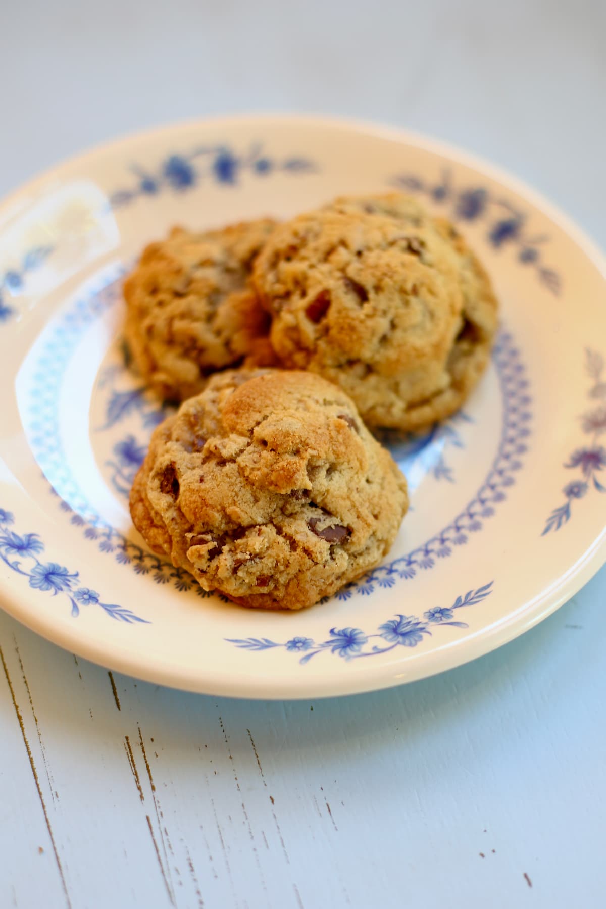 a plate of chocolate chip cookies on a blue table.  