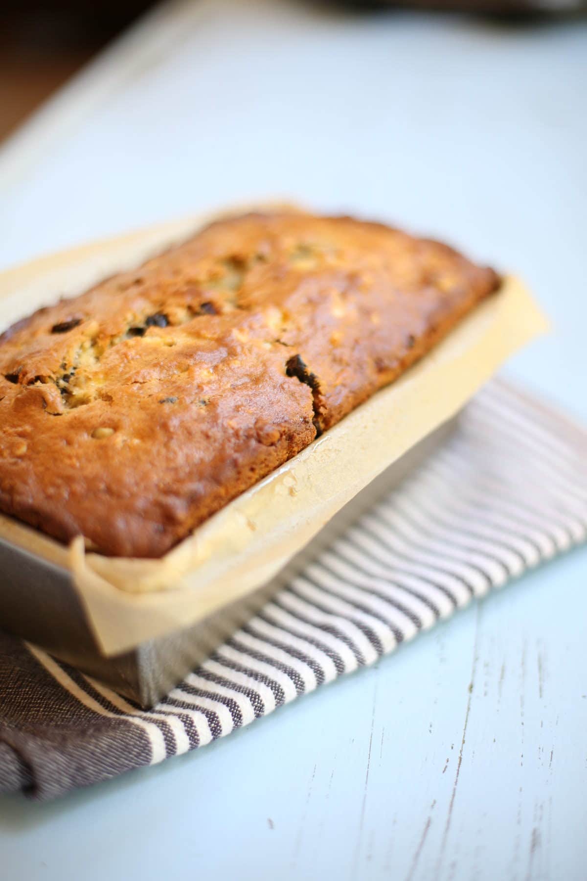 banana bread cooling on a striped dishcloth