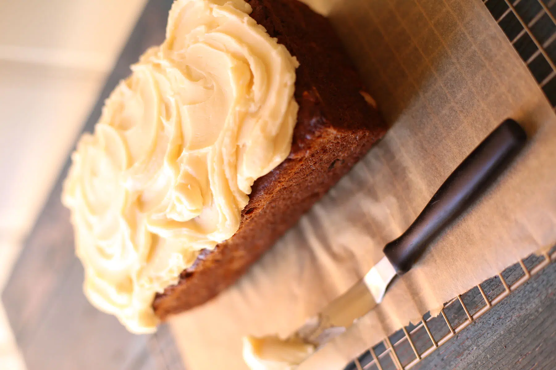 Banana bread on a table with frosting knife