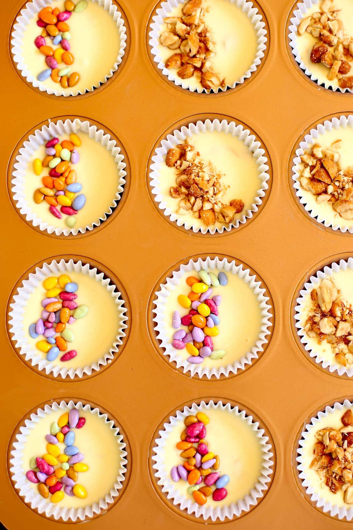 cups of white chocolate peanut butter cups with different toppings on them.