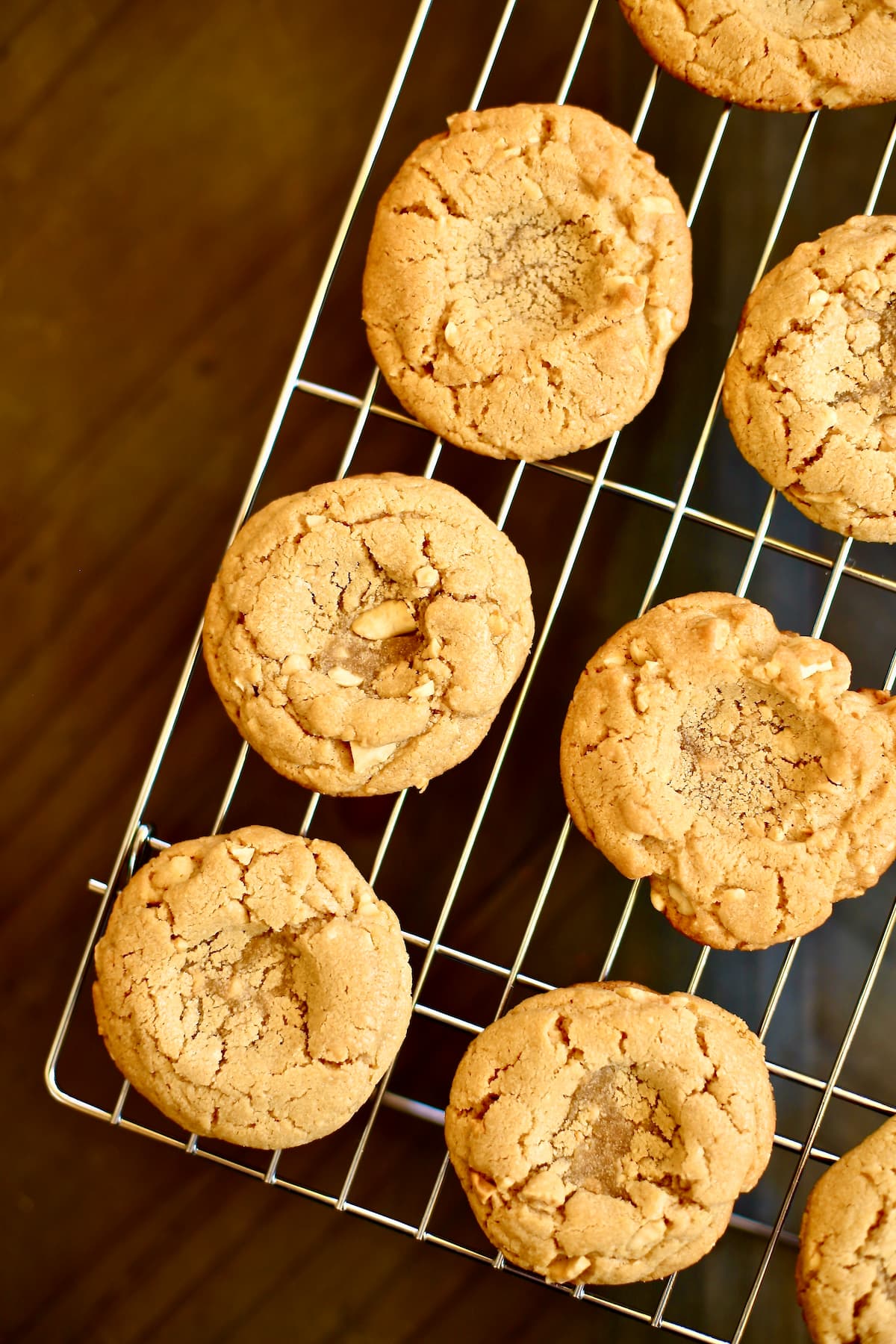 baked cookies with thumbprint centers for jam on a cooling rack.