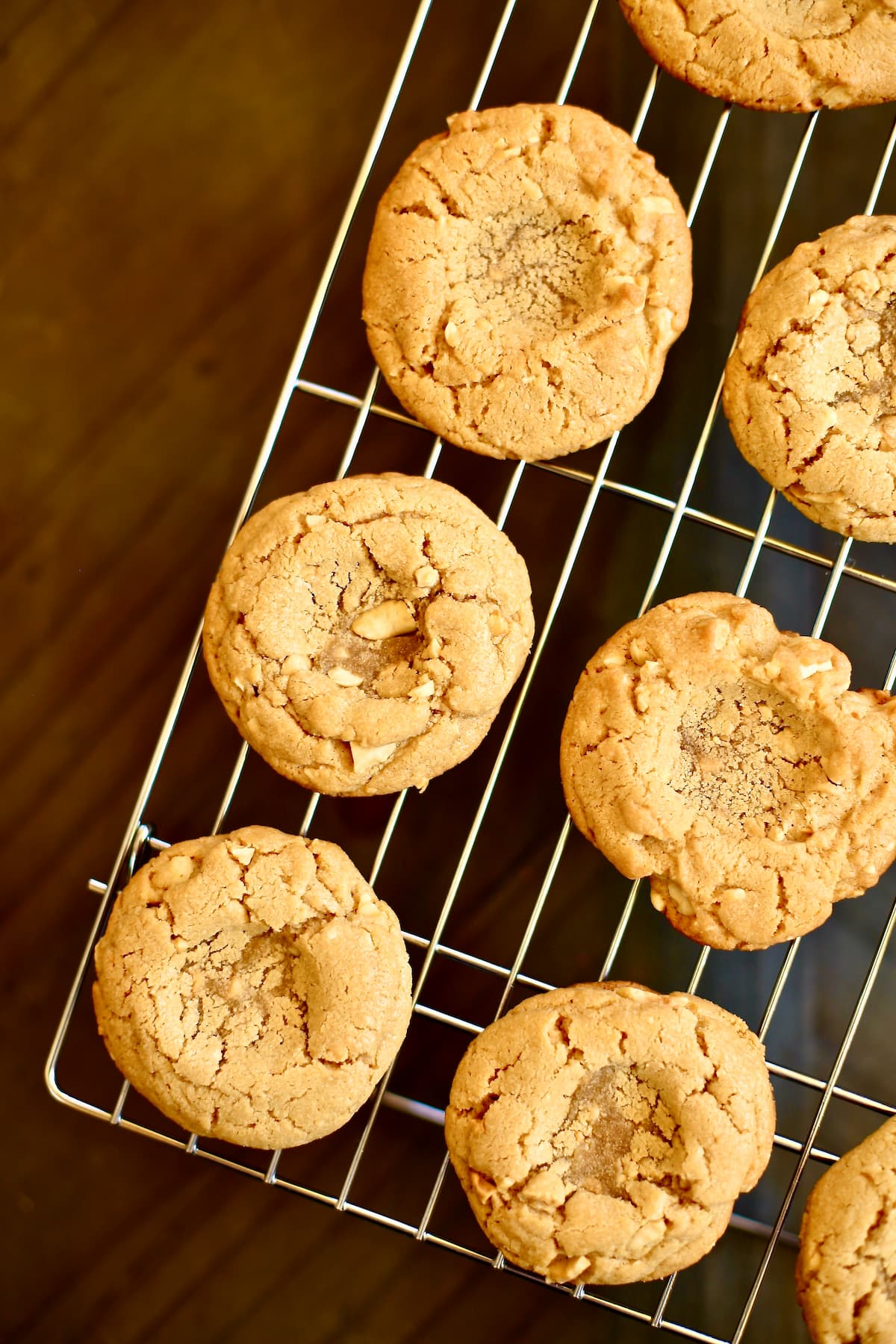 Peanut Butter and Jam Cookies baked cookies with thumbprint centers for jam on a cooling rack.