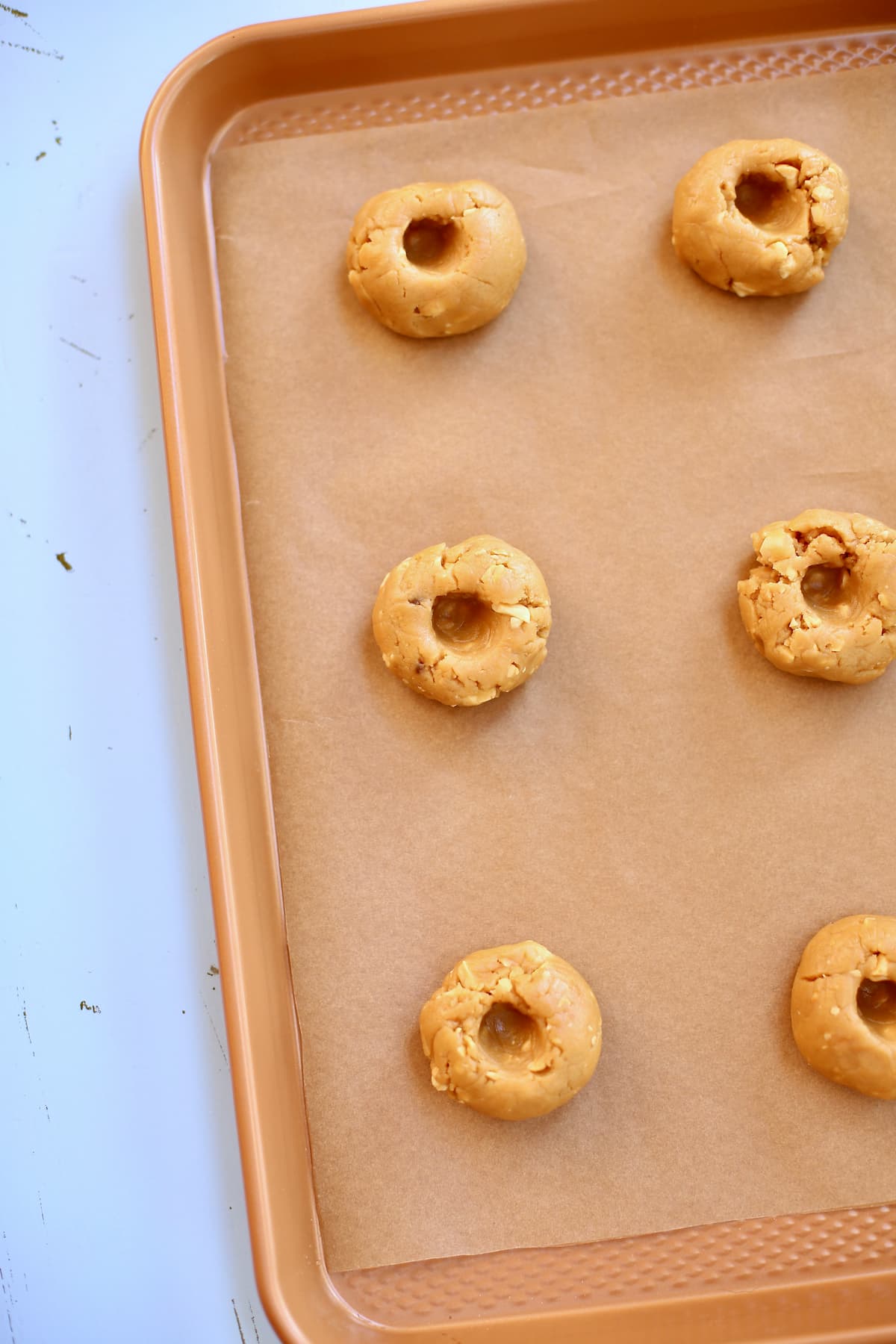Peanut Butter and Jam Cookies a baking tray of raw cookies.