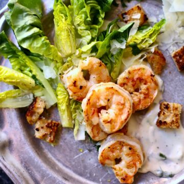 a silver platte with a shrimp salad on it.
