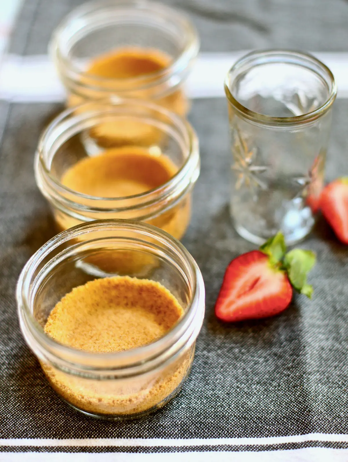three jars with graham cracker crust on a table 