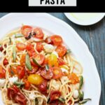 pasta with tomatoes on a white plate with black text