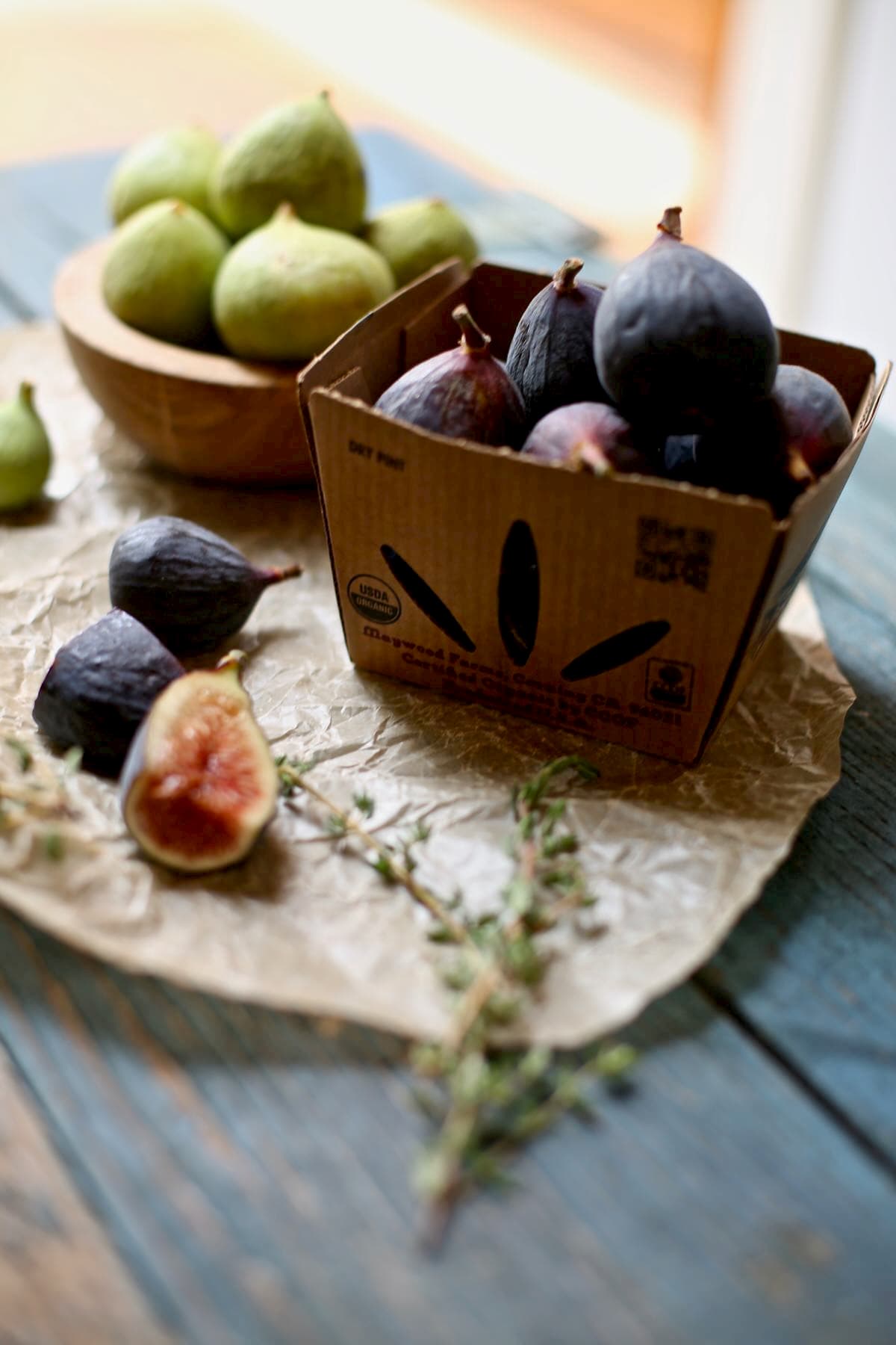 a basket of fresh figs on a blue table