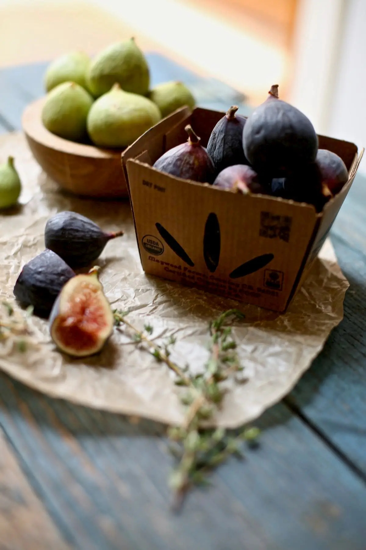 a basket of fresh figs on a blue table